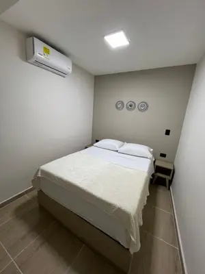 a bedroom with a large bed with two pillows at Laureles Inn in América
