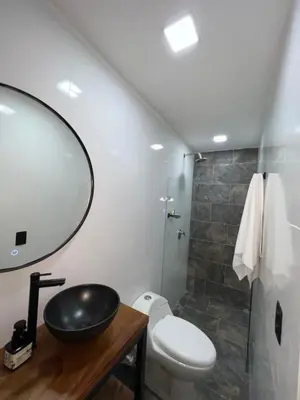 a bathroom with a sink and a toilet and a mirror at Laureles Inn in América