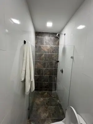 a bathroom with a shower and a toilet at Laureles Inn in América