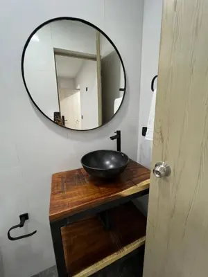a bathroom with a black sink and a mirror at Laureles Inn in América