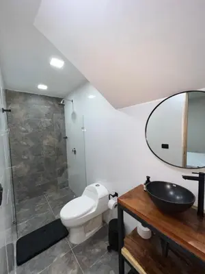 a bathroom with a toilet and a sink and a mirror at Laureles Inn in América