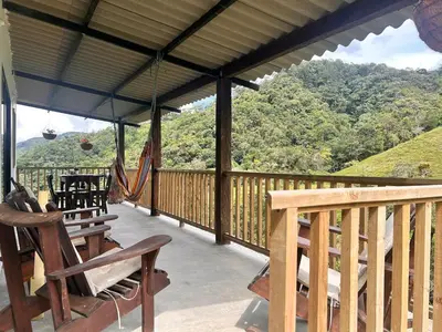 a porch with a hammock and a swing at Hospedaje Casa Madre los alemanes in Cháquiro