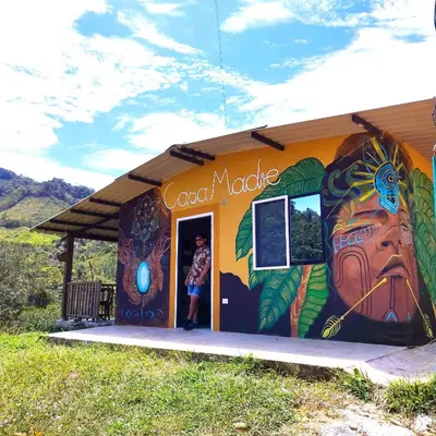 a person standing in the doorway of a building with a mural at Hospedaje Casa Madre los alemanes in Cháquiro