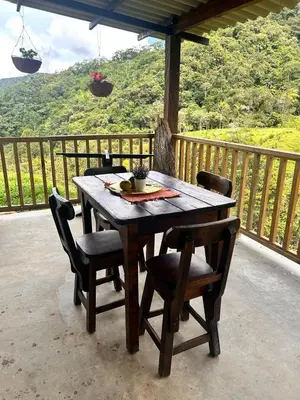 a wooden table and chairs on a balcony with a view at Hospedaje Casa Madre los alemanes in Cháquiro