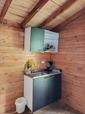 a kitchen with a sink in a wooden cabin at Refugio Natural - Cabañas Ecológicas con Jacuzzi, Guarne in Guarne