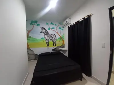 a bathroom with a painting of a zebra on the wall at HotelHR in Doradal