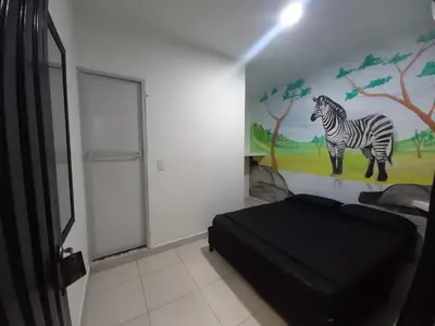 a bedroom with a painting of a zebra on the wall at HotelHR in Doradal