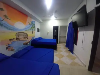a room with blue couches and a painting on the wall at HotelHR in Doradal