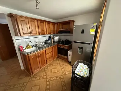 a small kitchen with wooden cabinets and a refrigerator at Apartamento Edicio Torreón en Rionegro in Rionegro