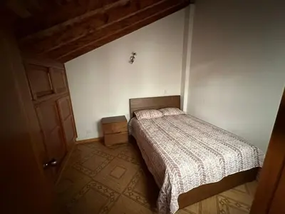 a small bedroom with a bed and a wooden floor at Apartamento Edicio Torreón en Rionegro in Rionegro