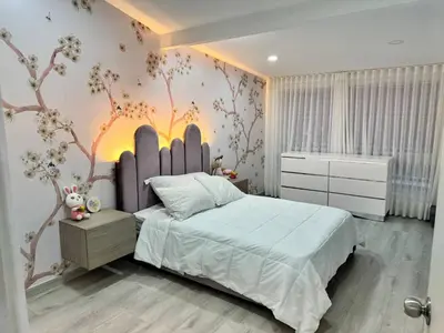 a bedroom with a bed with a tree mural on the wall at Luxury Home Medellin in El Poblado