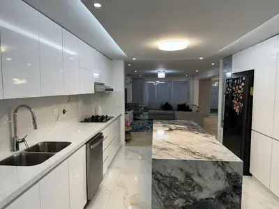 a kitchen with white cabinets and a marble counter top at Luxury Home Medellin in El Poblado