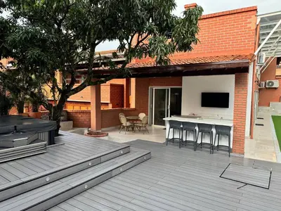 a patio with a table and chairs and a television at Luxury Home Medellin in El Poblado