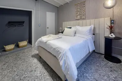 a bedroom with a large bed with white sheets and pillows at Hotel Hola Medellín in Medellín