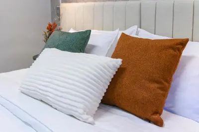 a pile of pillows sitting on top of a bed at Hotel Hola Medellín in Medellín