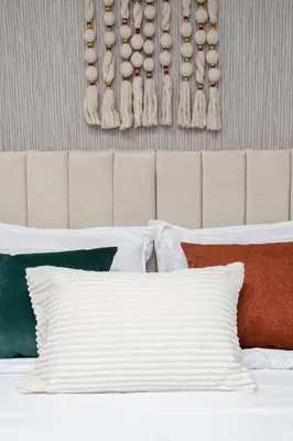 a bedroom with a bed with a headboard with eggs on the wall at Hotel Hola Medellín in Medellín