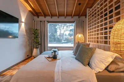 a bedroom with a large bed with a window at Casa Serena Provenza in Medellín