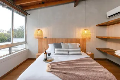 a bedroom with a large white bed with two lights at Casa Serena Provenza in Medellín