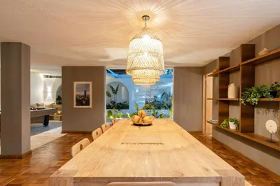 a dining room with a long table and a chandelier at Casa Serena Provenza in Medellín