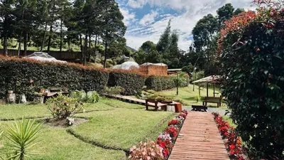 a garden with a wooden walkway and flowers at Boreal Refugio Natural in Sonsón