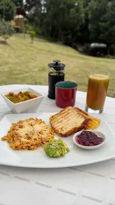 a table with a plate of food and a glass of juice at Boreal Refugio Natural in Sonsón