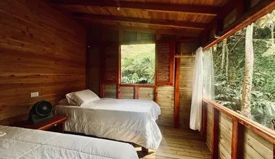 a log cabin with two beds and a window at Boreal Refugio Natural in Sonsón