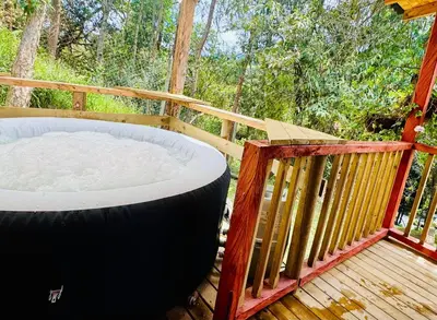 a hot tub on the deck of a cabin at Boreal Refugio Natural in Sonsón