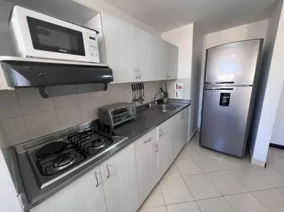 a kitchen with a stove and a microwave and a refrigerator at Envigado Sereno in Envigado