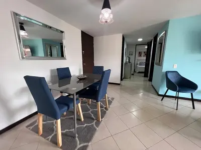 a dining room with a table and blue chairs at Envigado Sereno in Envigado