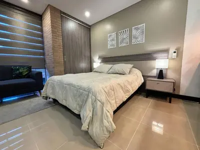 a bedroom with a bed and a chair in it at Oasis elegante Poblado in Medellín
