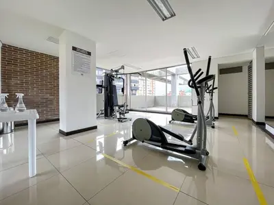 a gym with cardio equipment and a table in a building at Oasis elegante Poblado in Medellín