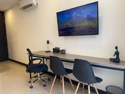 a room with a table with four chairs and a television at Oasis elegante Poblado in Medellín