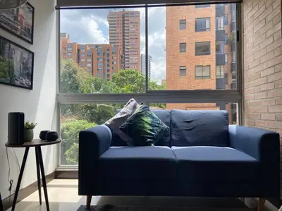 a blue couch in a room with a large window at Oasis elegante Poblado in Medellín