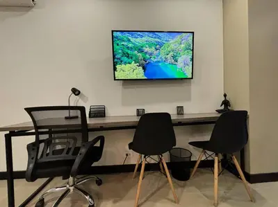 a room with two chairs and a table with a television on a wall at Oasis elegante Poblado in Medellín