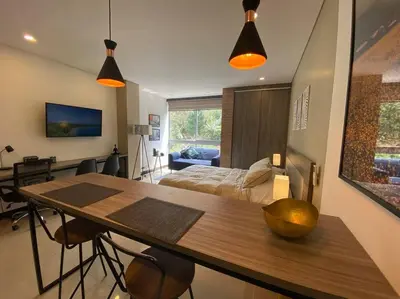 a room with a table and a bedroom with a bed at Oasis elegante Poblado in Medellín