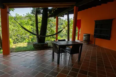 a table and chairs on a patio with a tree at Hospedaje RioBosque San Carlos in San Carlos
