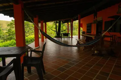 a hammock on the porch of a house at Hospedaje RioBosque San Carlos in San Carlos