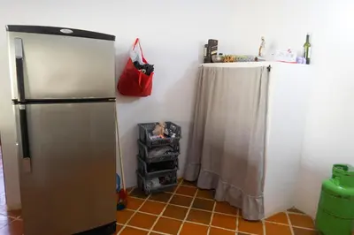 a kitchen with a refrigerator with a shower curtain at Hospedaje RioBosque San Carlos in San Carlos