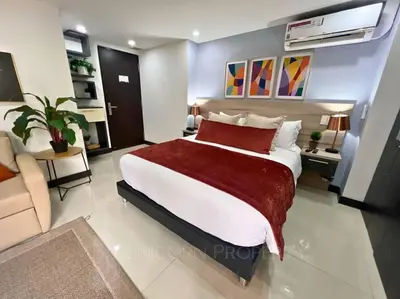 a bedroom with a large bed with a red blanket at Luxury Studio in El Poblado Modern Charm in Envigado