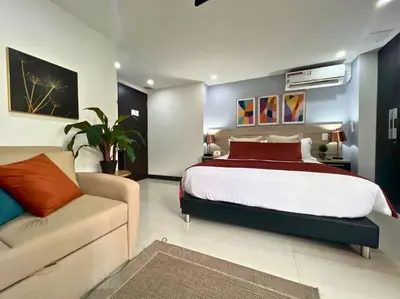 a bedroom with a large bed and a couch at Luxury Studio in El Poblado Modern Charm in Envigado