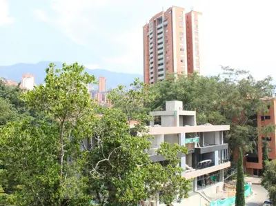 a tall building in the middle of some trees at Luxury Studio in El Poblado Modern Charm in Envigado