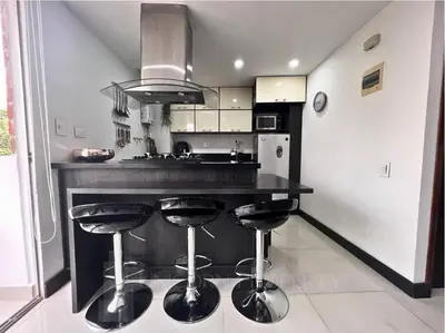 a kitchen with a black counter and stools in it at Luxury Studio in El Poblado Modern Charm in Envigado