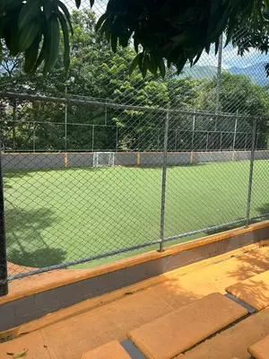 a tennis court with a chain link fence at Hermosa Cabaña Familiar in San Jerónimo