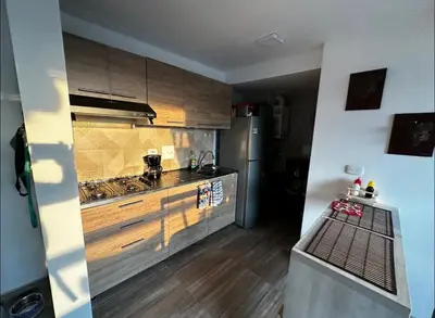 a kitchen with wooden cabinets and a stainless steel refrigerator at Excelente ubicación como en casa tranquilidad in Villamaría