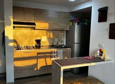 a kitchen with wooden cabinets and a stainless steel refrigerator at Excelente ubicación como en casa tranquilidad in Villamaría