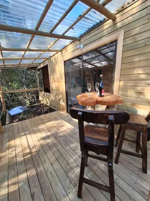 a patio with a table and chairs on a deck at Cabaña Del bosque in Santa Elena