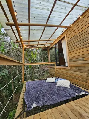 a bed in the middle of a wooden house at Cabaña Del bosque in Santa Elena