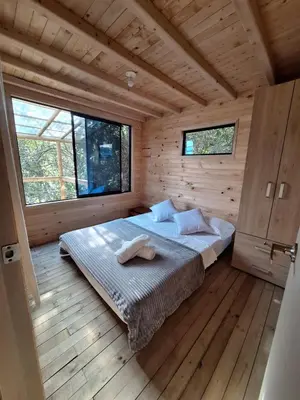 a bedroom with a bed in a wooden cabin at Cabaña Del bosque in Santa Elena