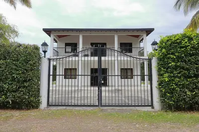 a gate in front of a white house at Acogedora Casa-Finca en Sopetran, Antioquia in Corral Falso