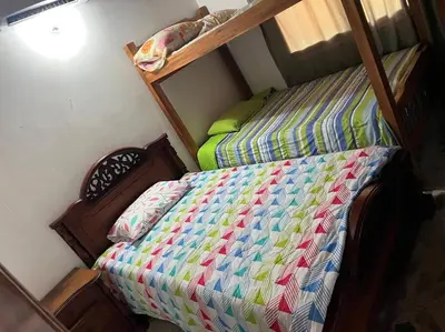 a bed with a colorful quilt on it in a room at Acogedora Casa-Finca en Sopetran, Antioquia in Corral Falso